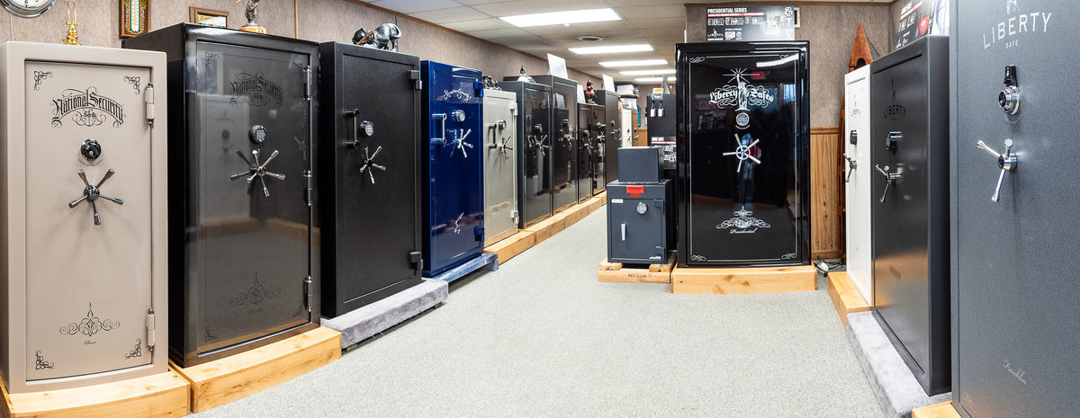 Row of various safes on display in a showroom.